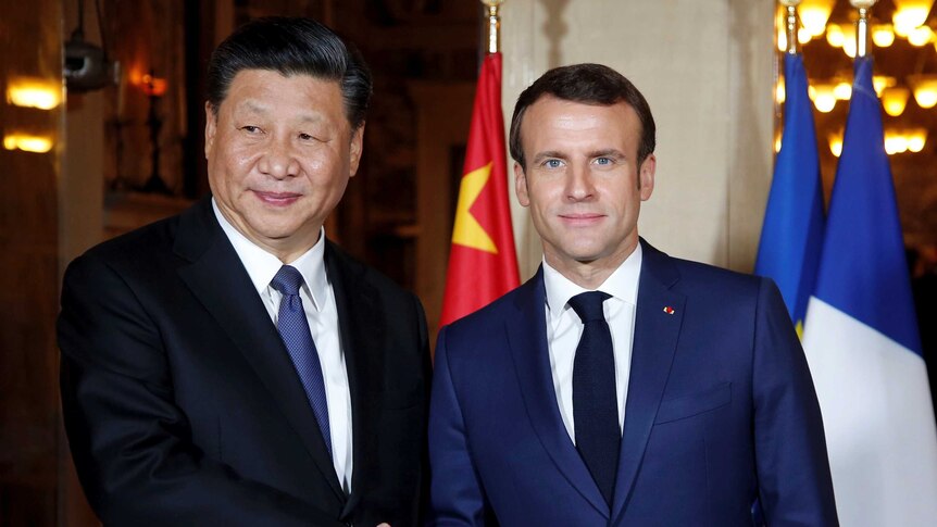 Chinese President Xi Jinping shakes hands with French President Emmanuel Macron.