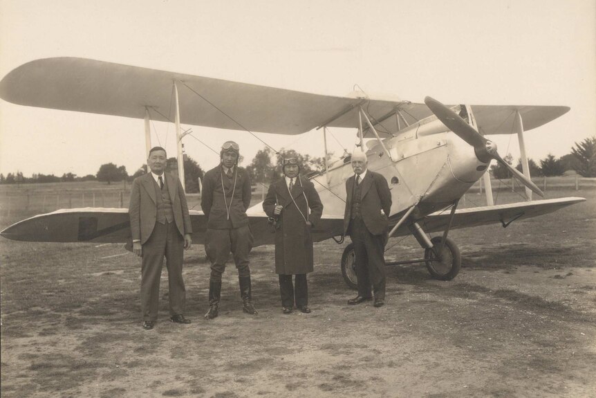 Four men standing in front of an old aircraft