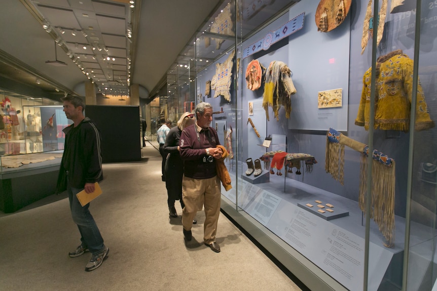 Люди рассматривают экспонаты в Музее американских индейцев. 