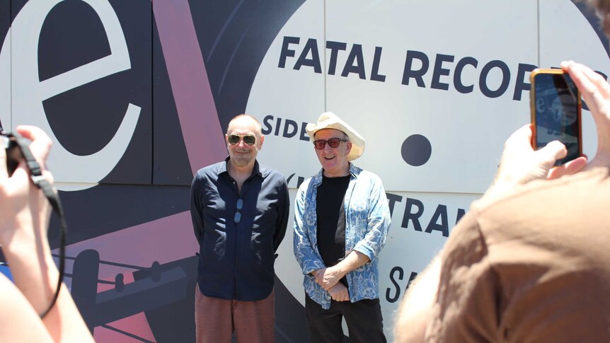Ed Keupper and Dr John Wilsteed standing together in front of a mural