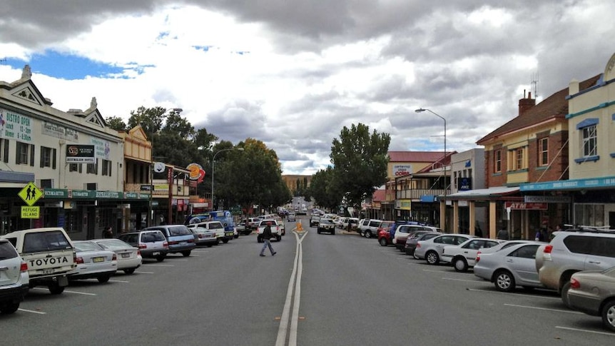 The main drag in a country town beneath a cloudy sky.