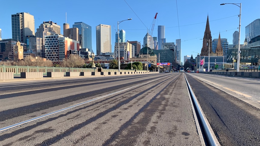 A low-angled photograph of the tram tracks running over Princes Bridge, viewed from Southbank with CBD visible.