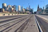 A low-angled photograph of the tram tracks running over Princes Bridge, viewed from Southbank with CBD visible.