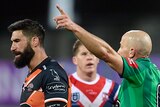 A referee points his raised finger towards the grandstands as he orders off the captain of an NRL team during a game. 