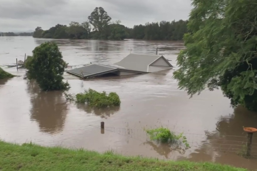 A home's roof is only just visible among floodwaters