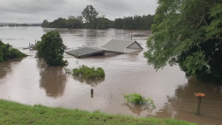 A home's roof is only just visible among floodwaters