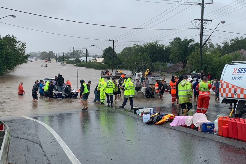 people stand on a flooded street