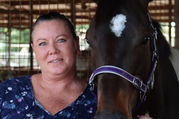 Horse trainer Nicole Bruggemann stands next to Darwin Cup winning horse Highly Decorated