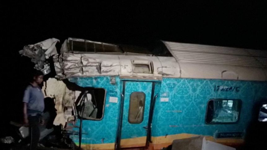 A view of a damaged compartment of a derailed train. 