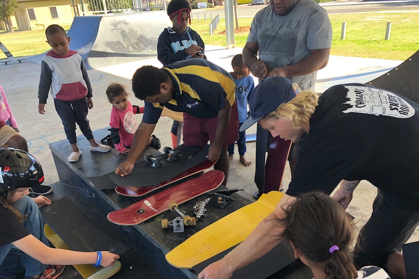 Children in Murgon, Queensland being taught how to build a skateboard.