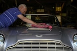 A man cleaning his Aston Martin car.