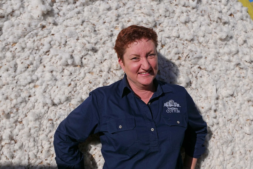 Southern Cotton CEO Kate O'Callaghan stands against a bale of cotton.