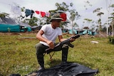 FARC rebel cleans his weapon at a camp in La Carmelita, Colombia.
