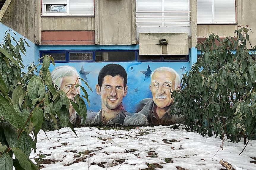 A mural of Novak Djokovic with his grandfather and a tennis mentor in Belgrade.