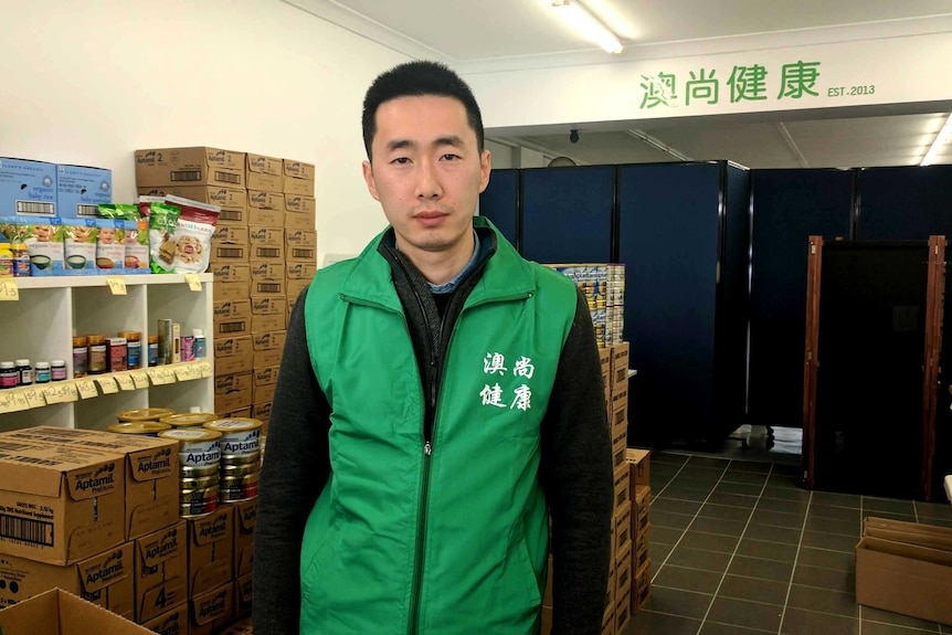 Allen Xin, owner of Aoshang Health, is standing in his Carnegie shop.