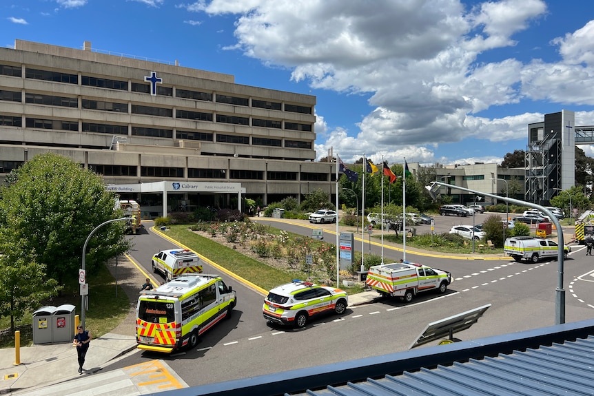 Three emergency vehicles outside a hospital.