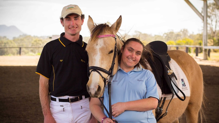 Kyle Chapman and Melissa Madafiglio stand next to a horse.
