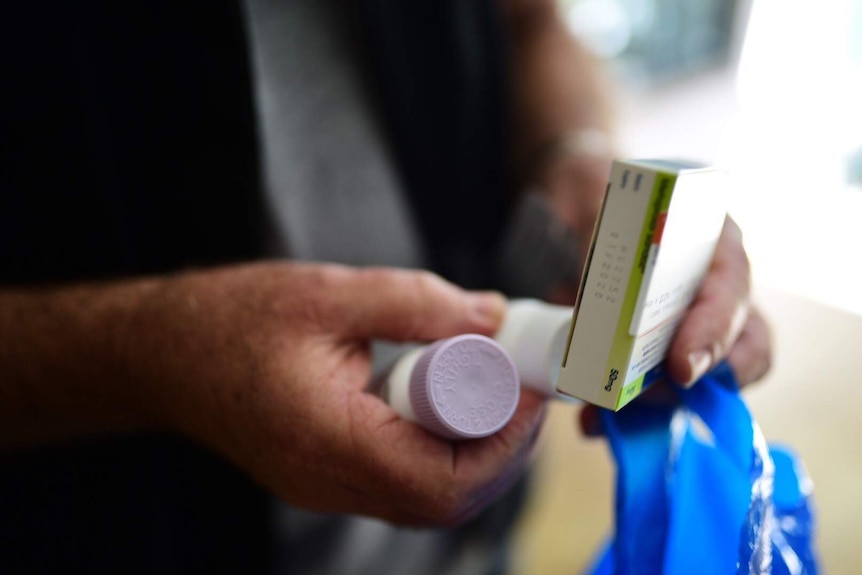 Man holding several medicines