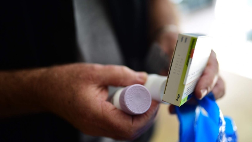 Man holding several medicines