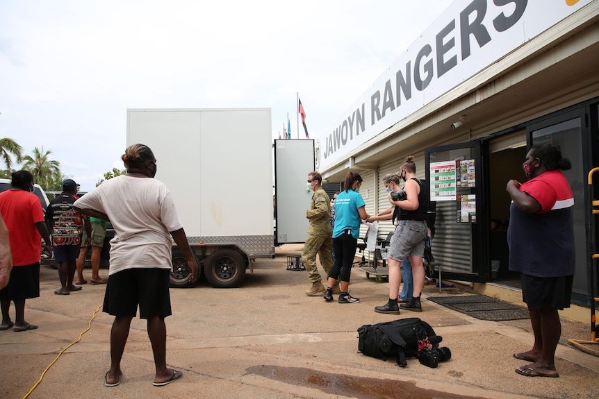 people collecting bags of food from a truck