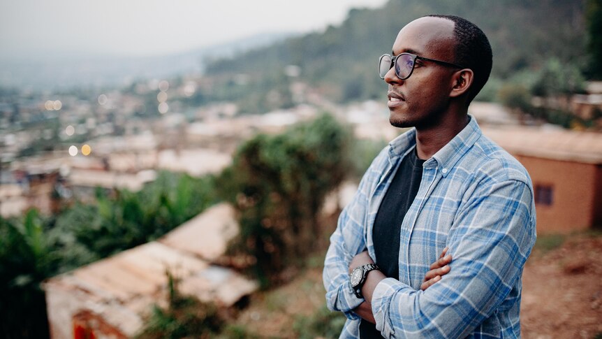 A contemplative Rwandan man looking out over an African village