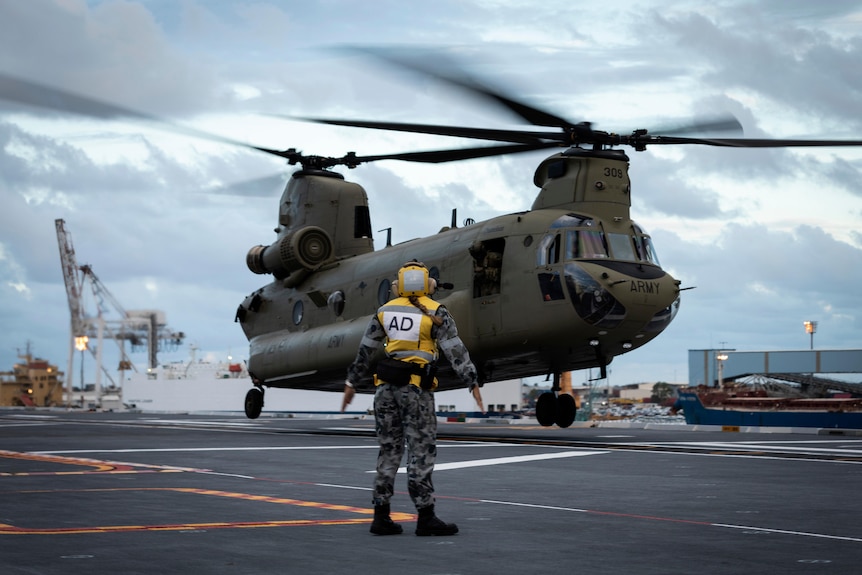 A helicopter lands on a naval vessel