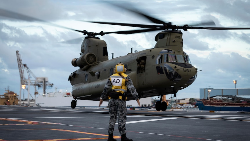A helicopter lands on a naval vessel