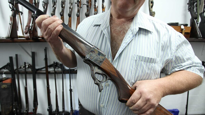 An unidentified gun collector holds one of his weapons.