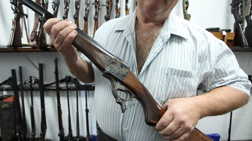 An unidentified gun collector holds one of his weapons.