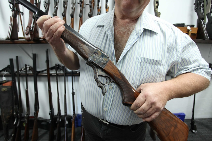 An unidentified gun collector holds one of his weapons.