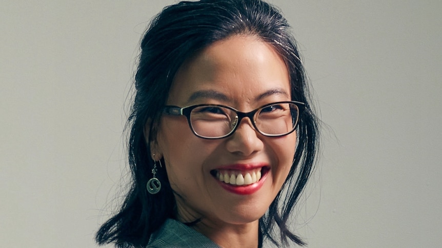 Photo of a widely smiling woman wearing glasses 