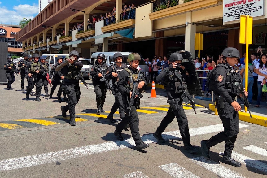 Armed police arrive at the V-Mall where gunshots rang out in Manila.