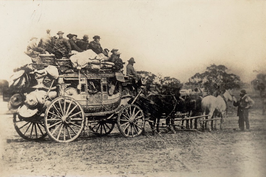 Men sitting on horse drawn carriage.