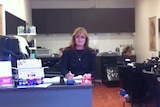 Woman standing behind counter at a hairdressing salon. 