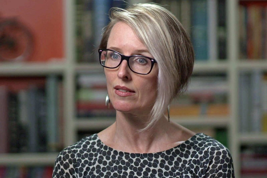 Katherine Boyle wears glasses and a black and white top.