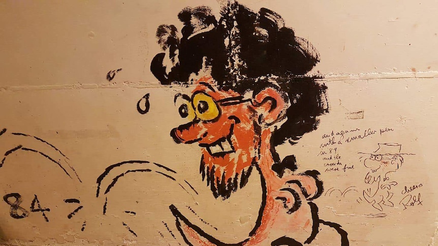 Two sketches of a man's face with black curly hair wearing glasses on a kangaroo's body on a pale coloured wall