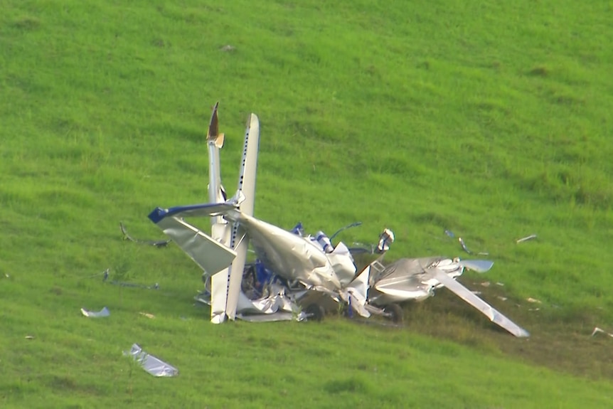 A smashed plane on the grass.