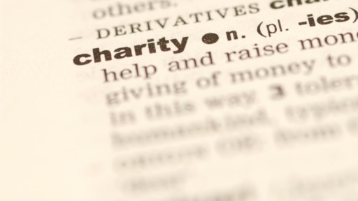 Dictionary open at the definition of charity (Thinkstock: Hemera Technologies)
