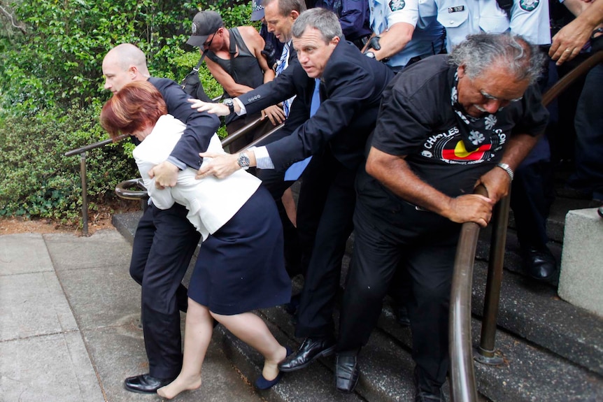 Police and bodyguards escort Julia Gillard and Tony Abbott