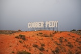 A sign saying Coober Pedy similar to the Hollywood sign.