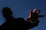 Scott Morrison has a shadow over his body except for his hand, which is reaching out