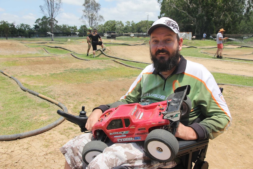 A man sits at a manicured racetrack