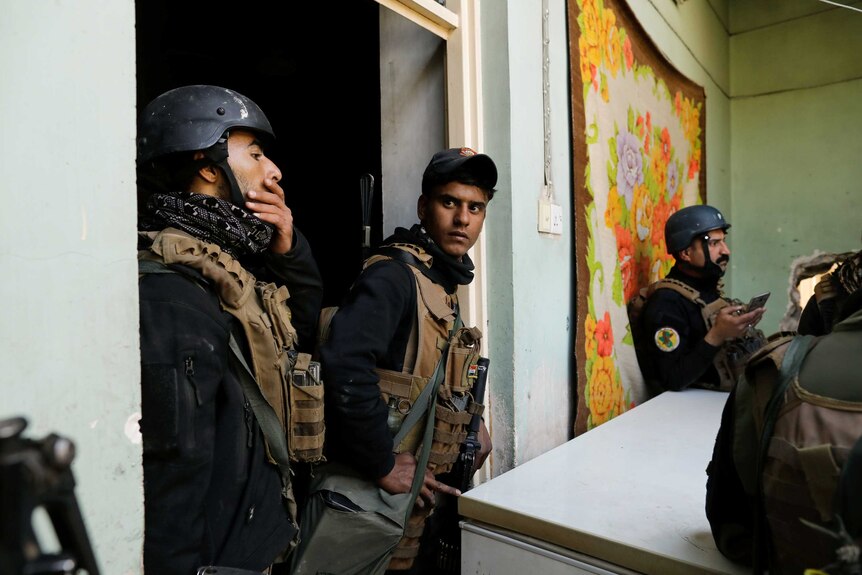Special forces members wait inside a house during a battle with Islamic State militants in western Mosul