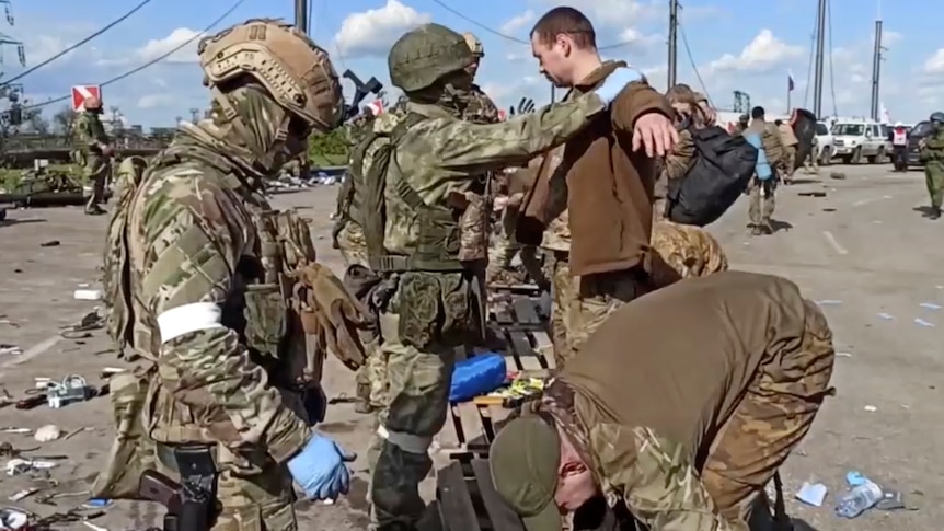 Russian servicemen frisk Ukrainian servicemen after they leaved the besieged Azovstal steel plant in Mariupol.