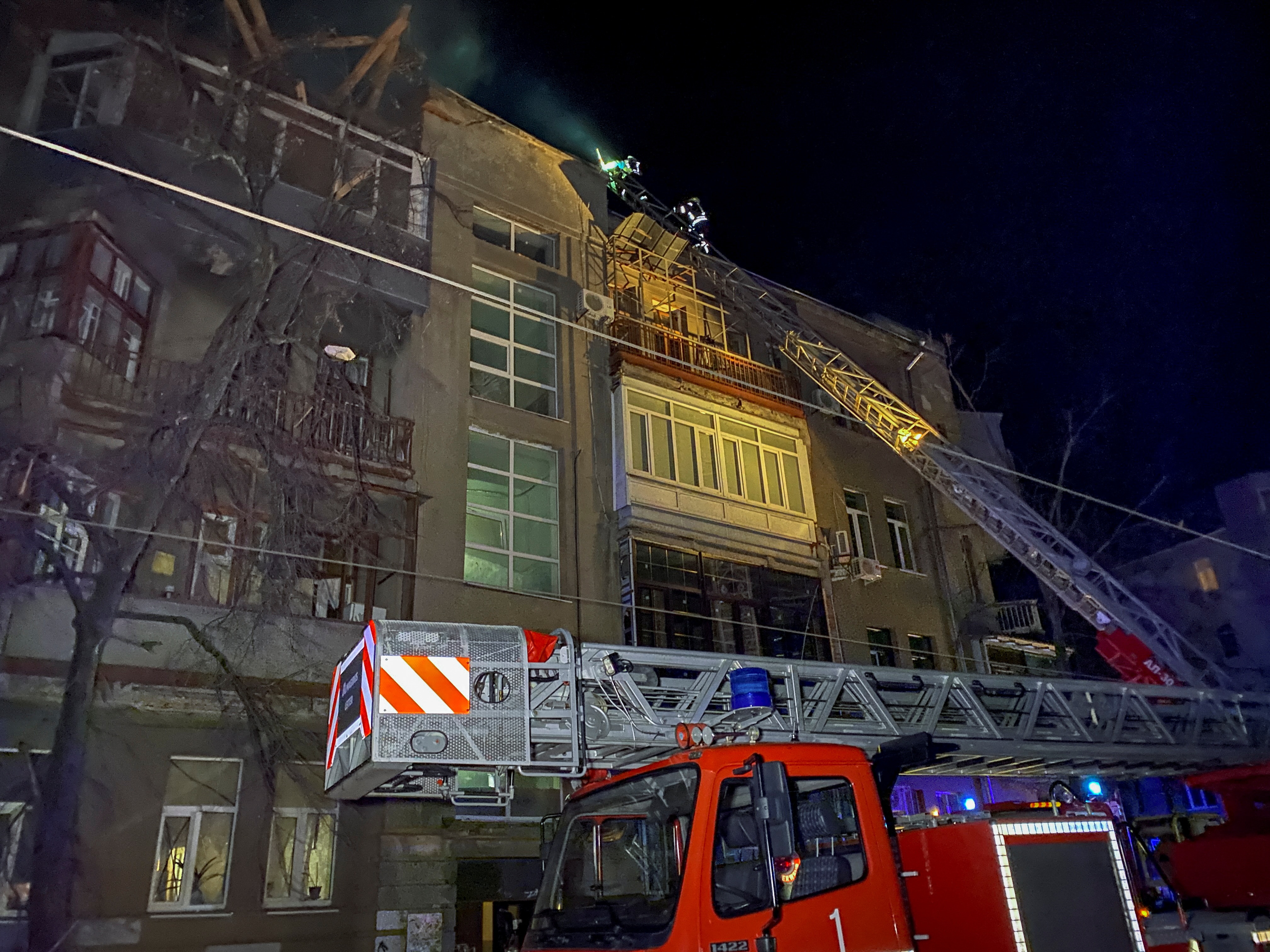 Ukrainian firefighters work at a site of an apartment building severely damaged by a Russian missile.