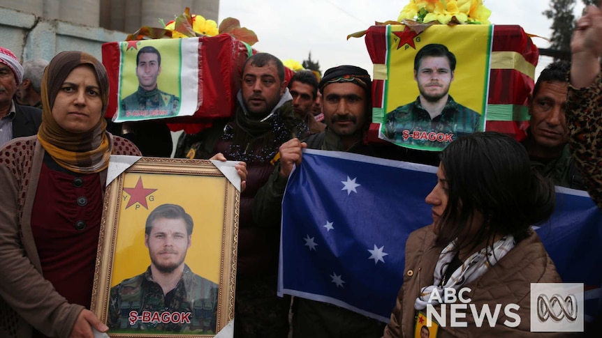 Kurdish fighters carry coffins, pictures and Australian flag