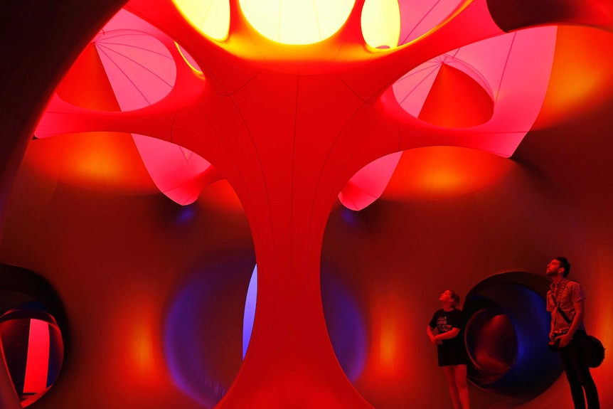 Two people inside the imaginarium EXXOPOLIS room which features a tree-like section.