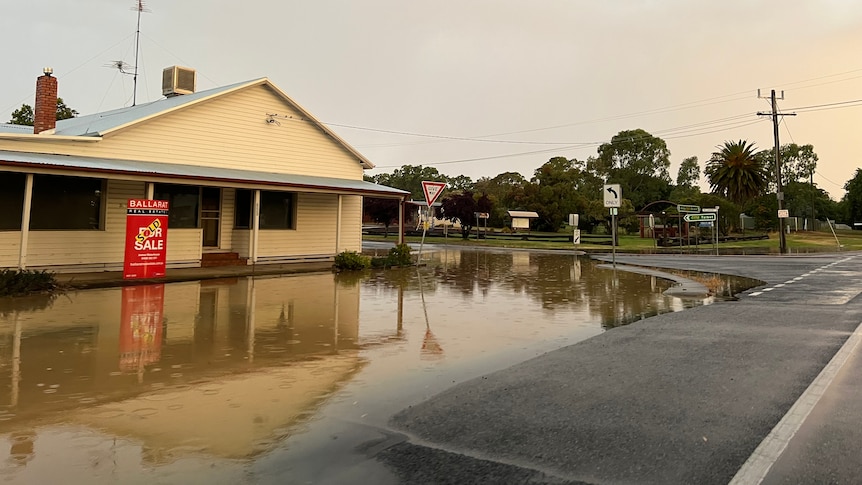 water pooled in front of a shopfront by a roadside