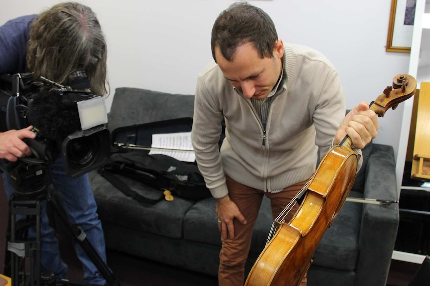 Antoine Tamestit shows the viola to an ABC cameraman.