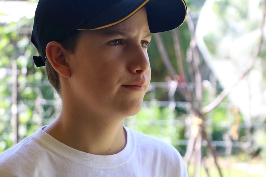 Close-up of teenage beekeeper Luke de Laeter wearing a black cap.